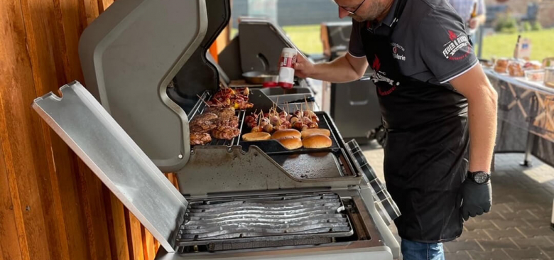 Grillmeister bereitet Burger und Fleisch zu