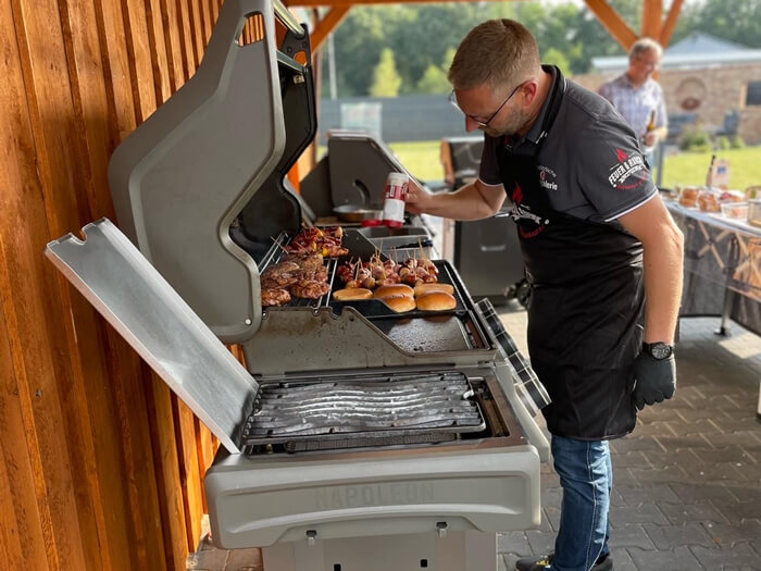 Grillmeister bereitet Burger und Fleisch zu