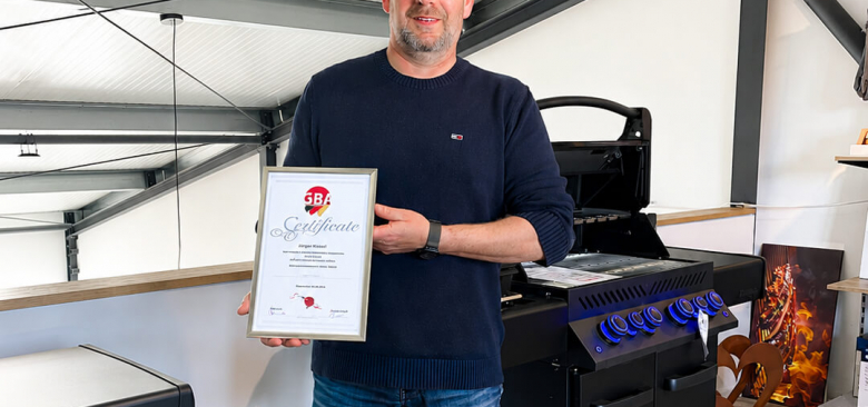 Mann mit Grillzertifikat im Showroom